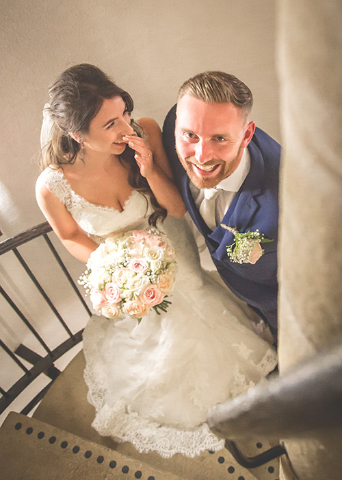 bride and groom on stairwell laughing