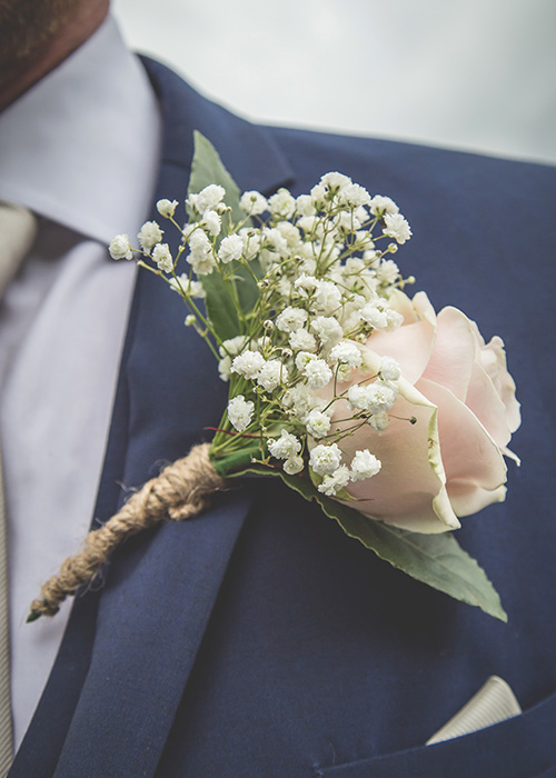 buttonhole pink flower blue suit