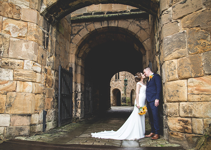 bride and groom in archway alnwick castle