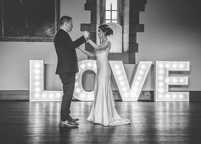 first dance in front of lit up letters